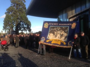 Brendan Murran and Paddy Moran of SIPTU raise ITGWU Banner with image of Alicia Brady, JohnByrne and James Nolan on it. All died in 1913 Lockout